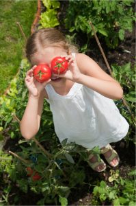 Mädchen hat Tomaten auf den Augen