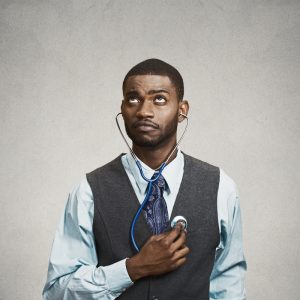 Mann hört sich selbst mit Stethoskop ab