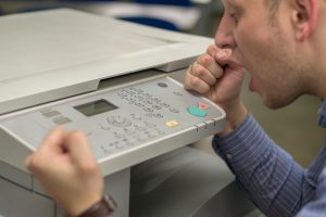 Mann verzweifelt am Kopierer