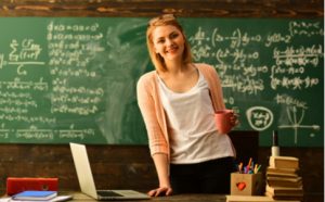 Lehrerin an ihrem Pult mit Laptop