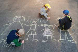 Kinder malen Familie mit Kreide auf Straße