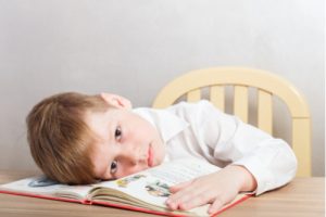 kleiner Junge alleine mit Bilderbuch