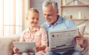 Vater und Tochter lernen mit Tablet und der Sprachzeitung Englisch