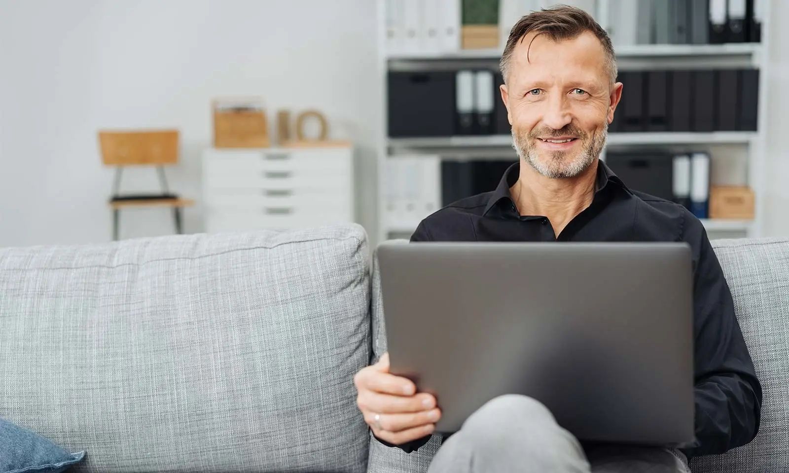Frau schreibt und schaut auf ihren Laptop