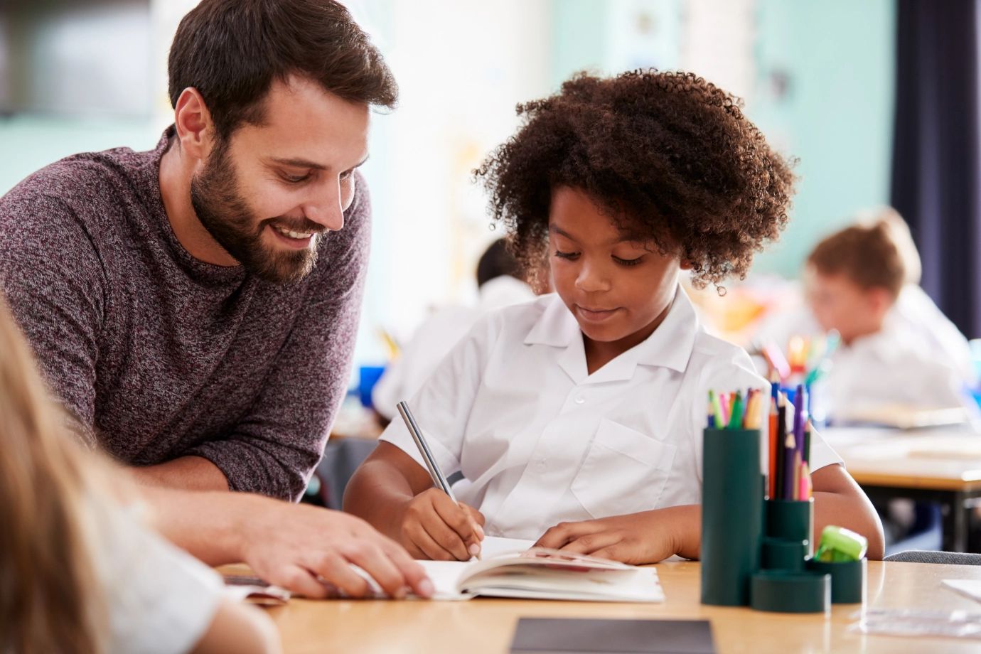 Teacher helping a student in a classroom setting